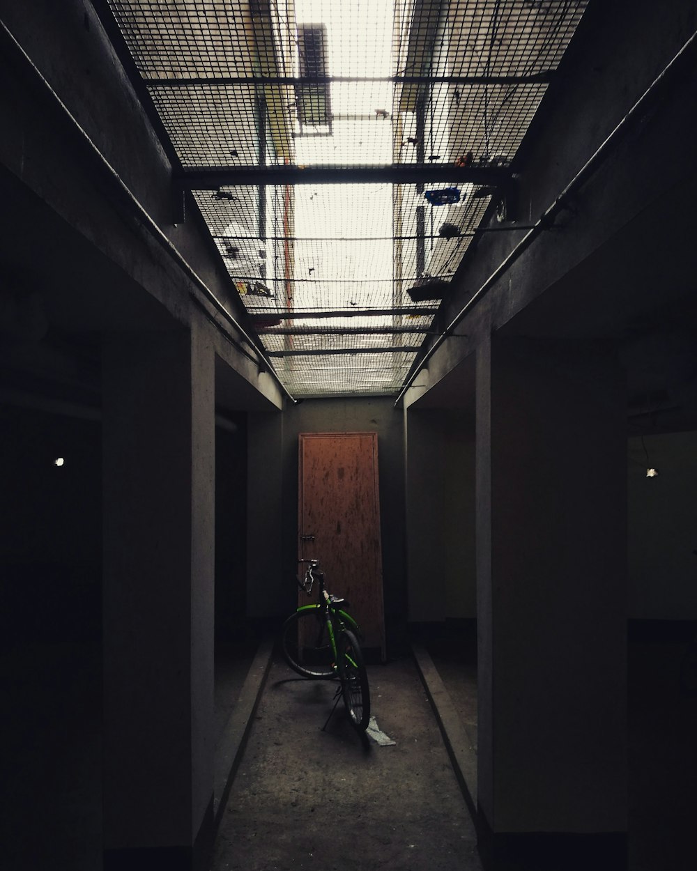 green bicycle parked on hallway