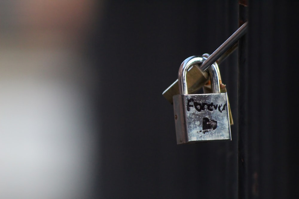 brass padlock on black metal bar