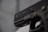 A close-up view of a black handgun, with visible engravings including the brand and model details. The focus is on the slide of the firearm.
