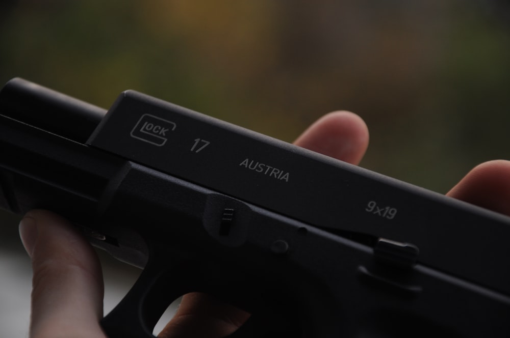 person holding black semi automatic pistol