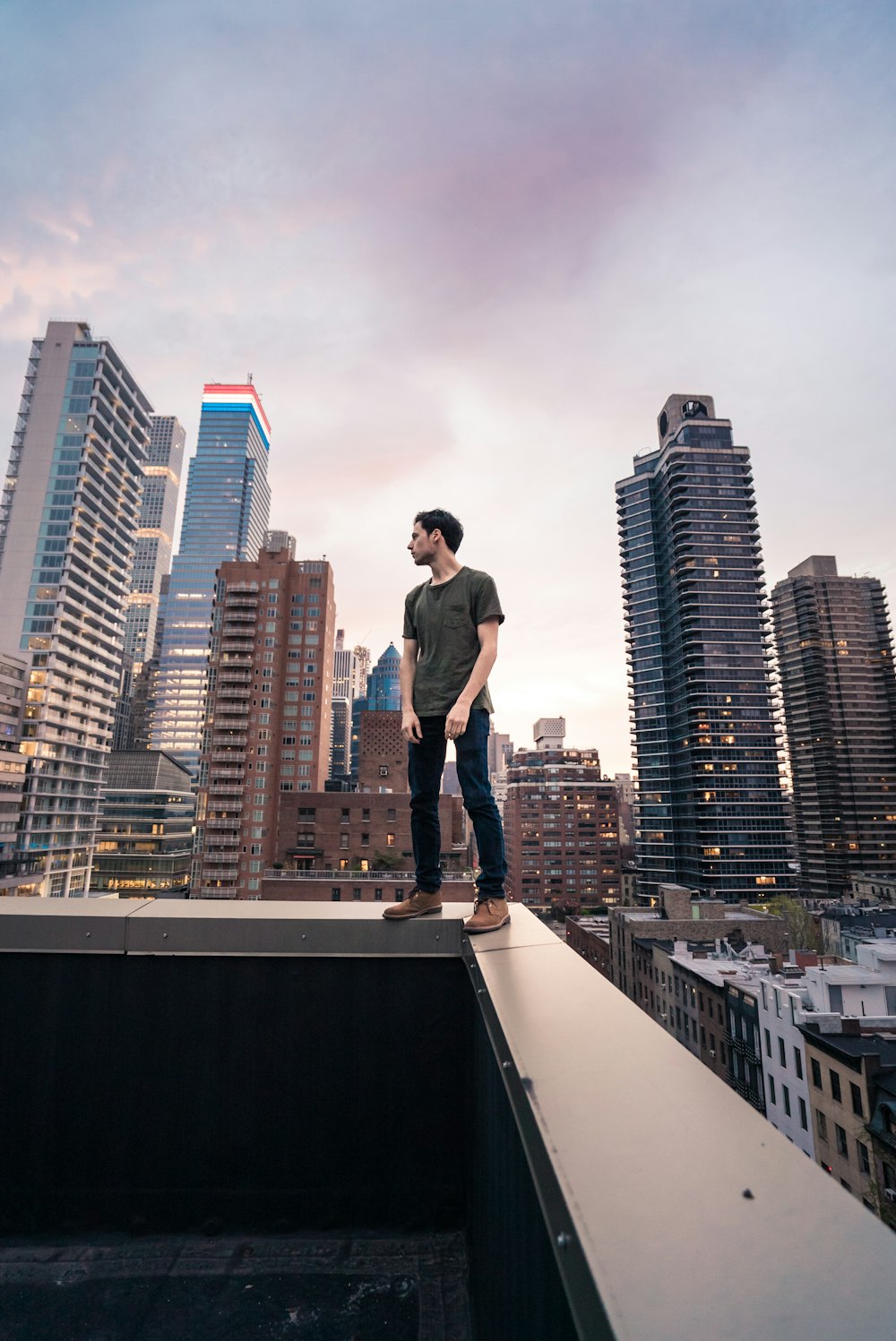 a man standing on top of a roof in a city