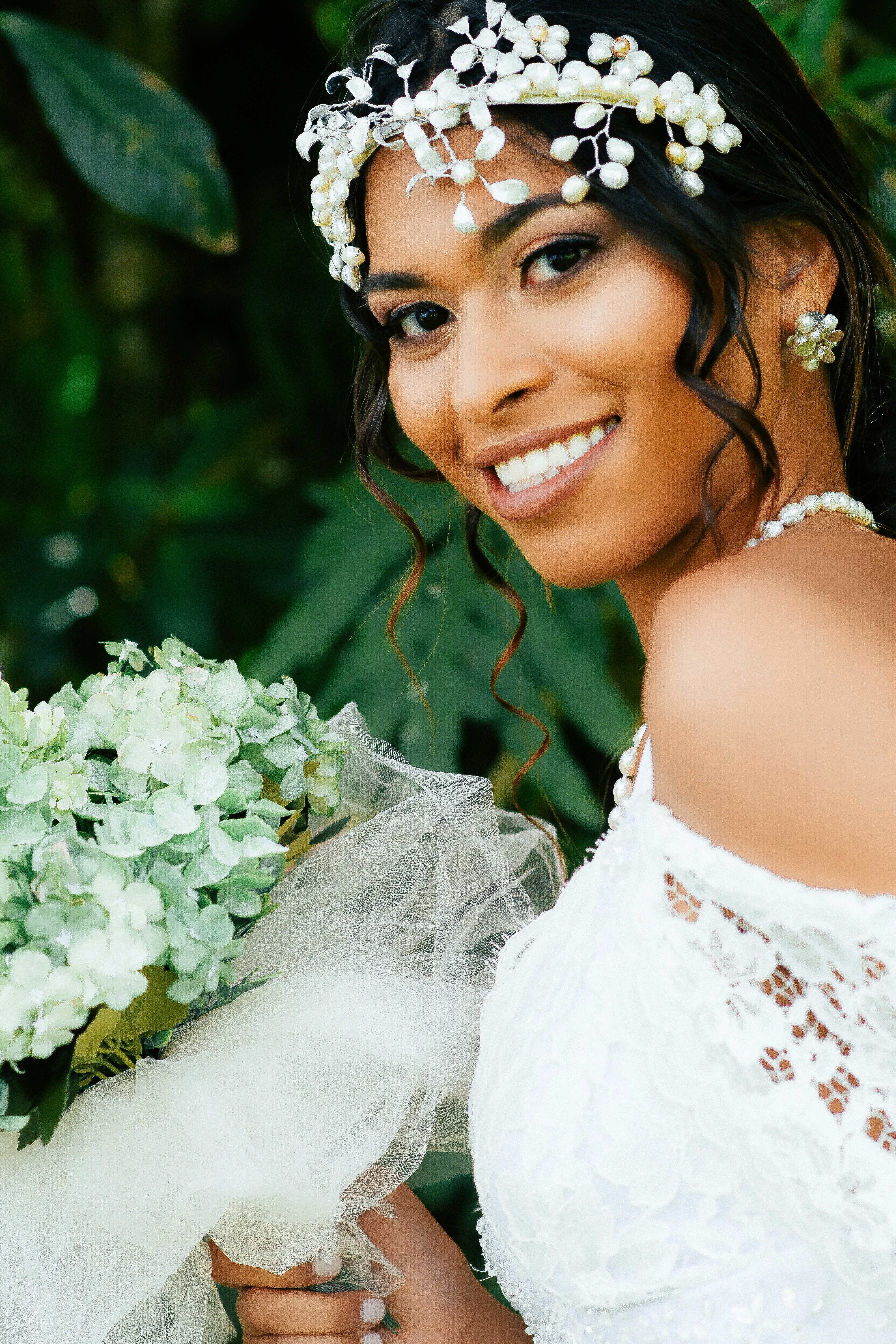 smiling woman in white floral dress wearing white floral crown