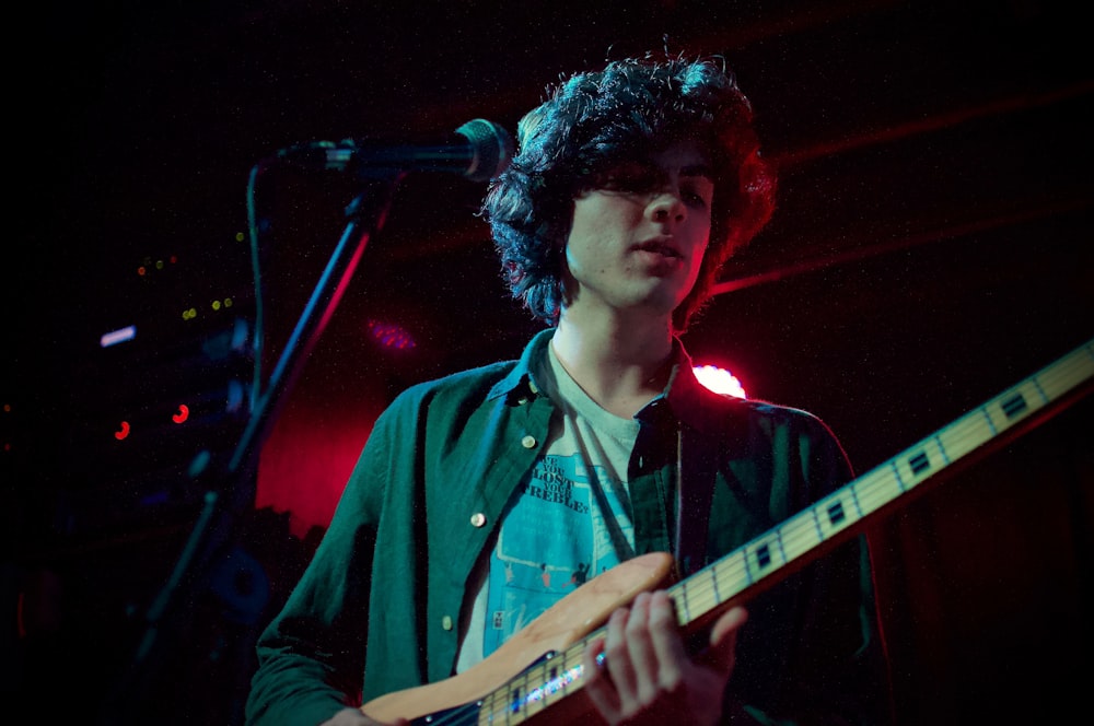 man in blue button up shirt playing guitar