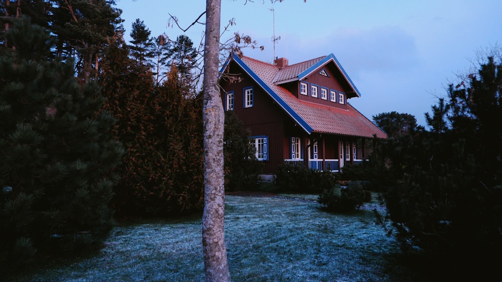 brown and white house near green trees under blue sky during daytime