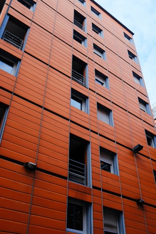 Architectural model of a modern building with orange highlights on a gray base.