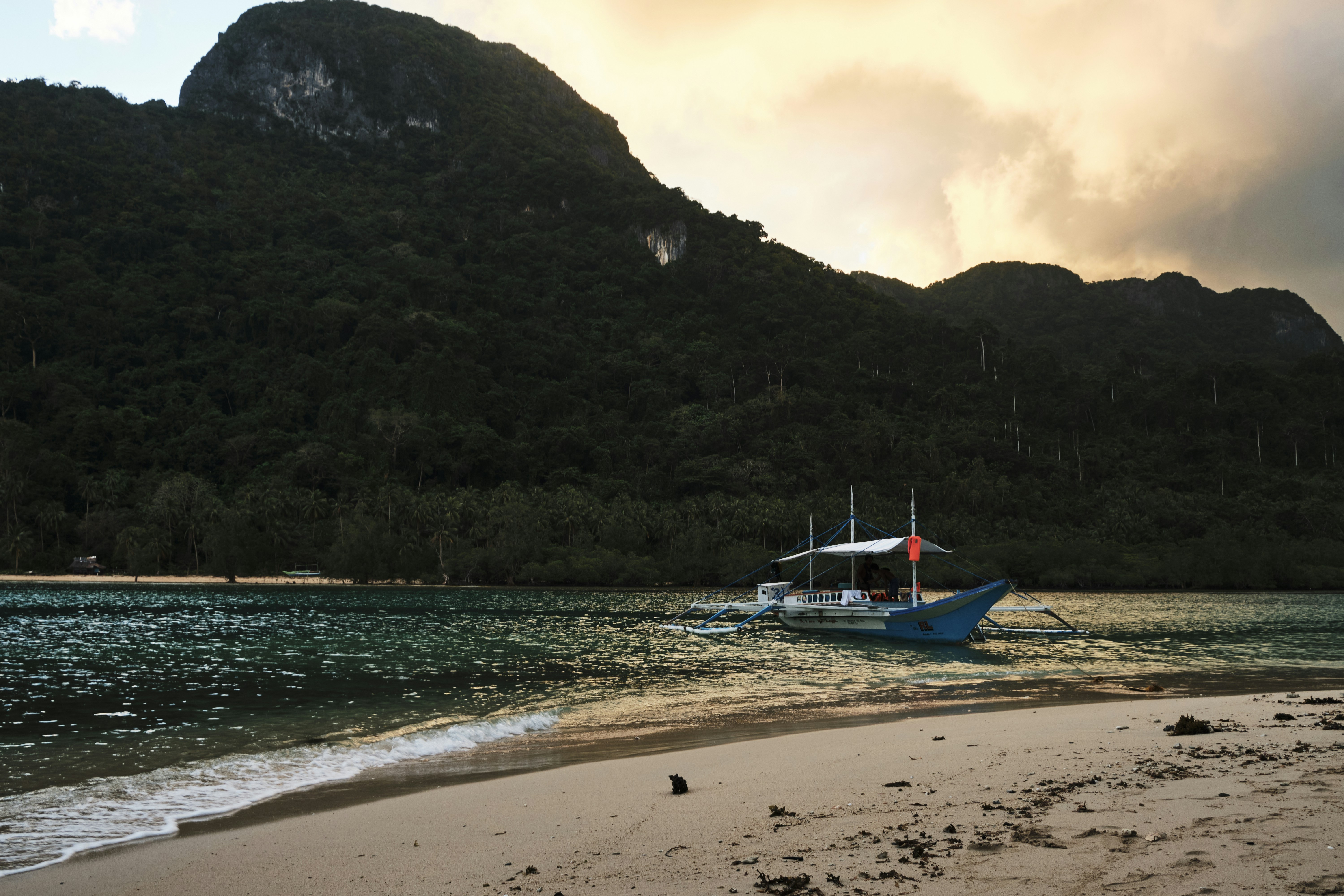 blue and white boat on shore during daytime, Private beach and beautiful sunset in El Nido