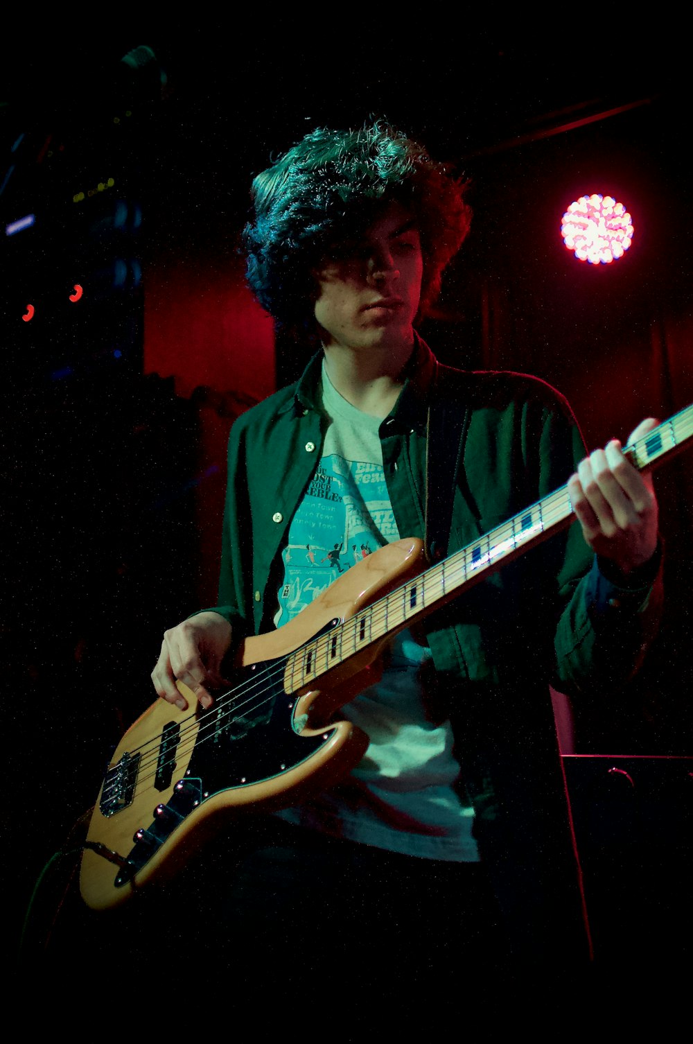 일렉트릭 기타를 연주하는 녹색 버튼 업 셔츠를 입은 남자