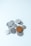 A collection of assorted coins with one larger brown coin placed prominently on top of several smaller silver coins on a light blue surface.