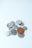 A collection of assorted coins with one larger brown coin placed prominently on top of several smaller silver coins on a light blue surface.