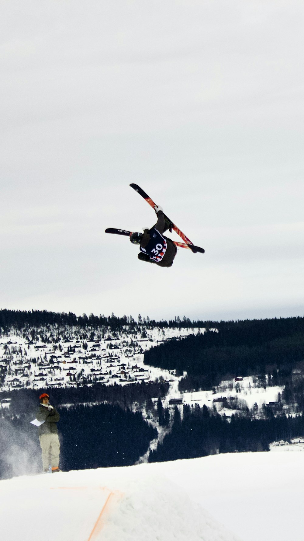 person in red jacket riding red and black snowboard on snow covered ground during daytime