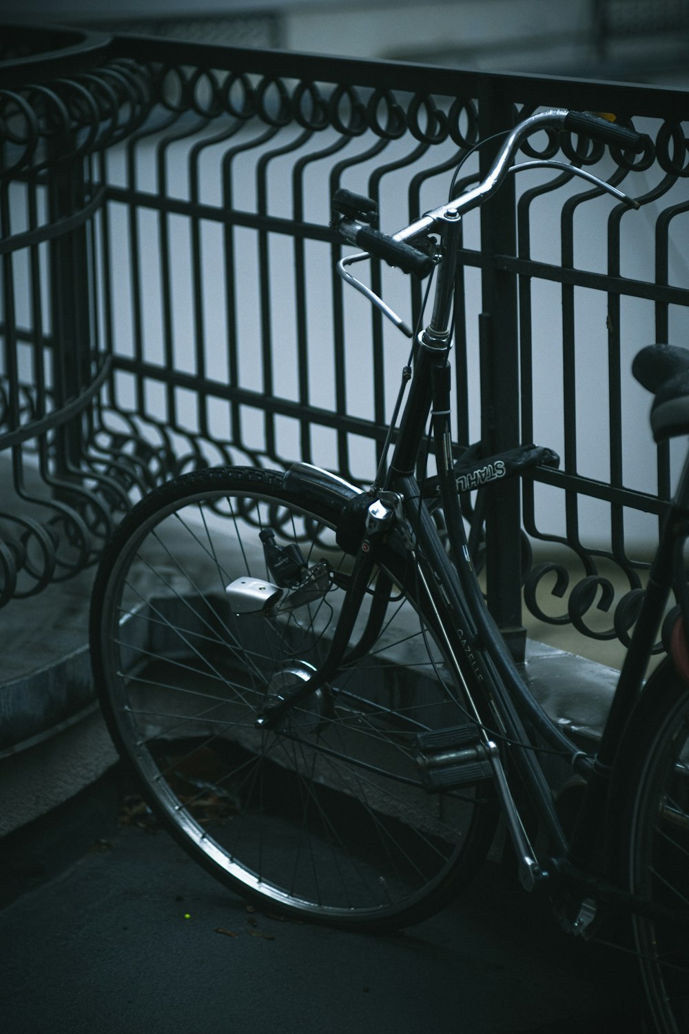 black commuter bike beside black metal fence