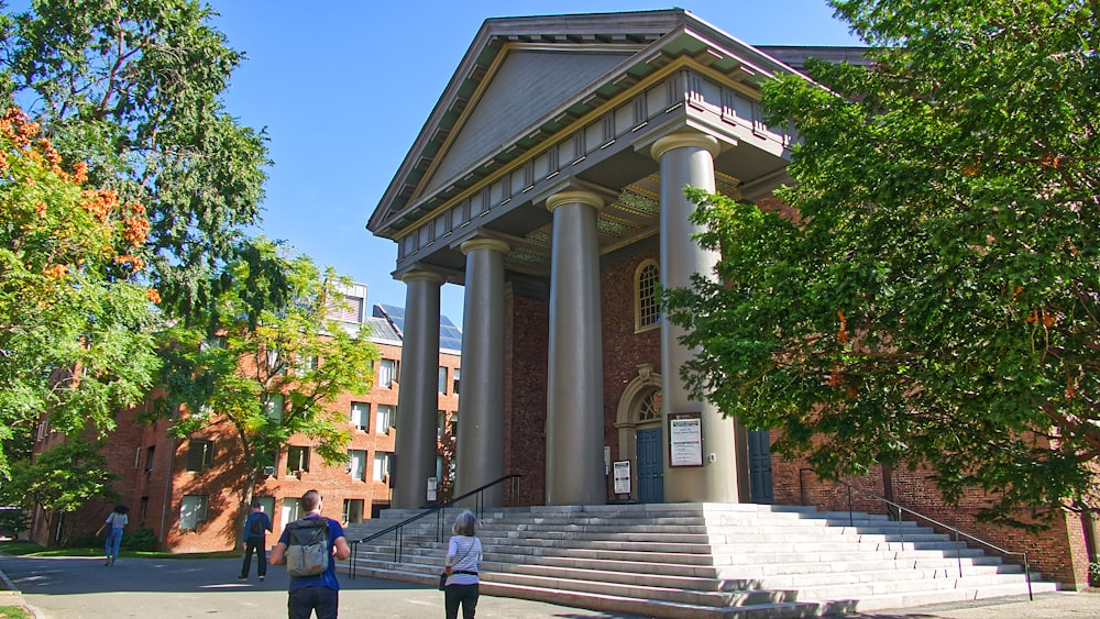 people walking on sidewalk near building during daytime