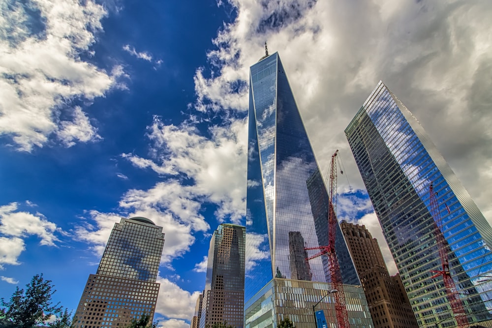 low angle photography of high rise buildings under blue sky and white clouds during daytime