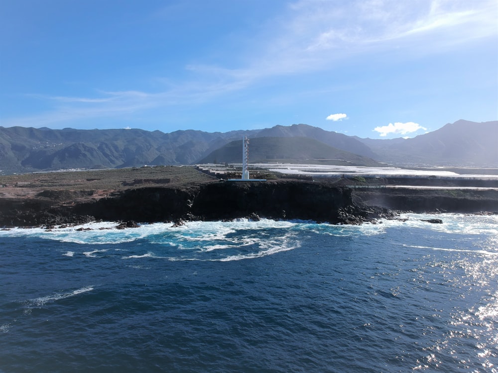 body of water near mountain under blue sky during daytime