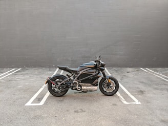 A sleek motorcycle and car parked side by side in a minimalist urban setting.