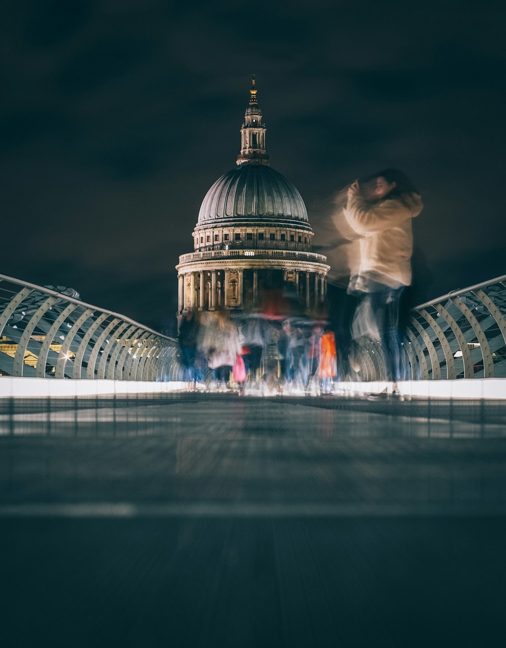 woman in white shirt standing in front of white and blue dome building during nighttime