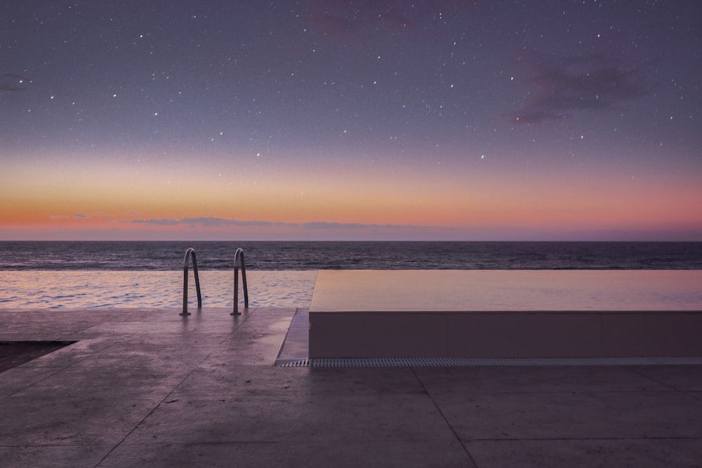 silhouette of person standing on sea dock during sunset