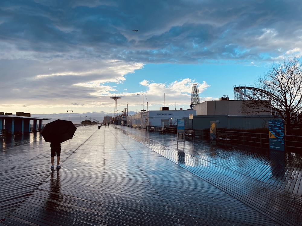 person walking on dock under blue sky during daytime