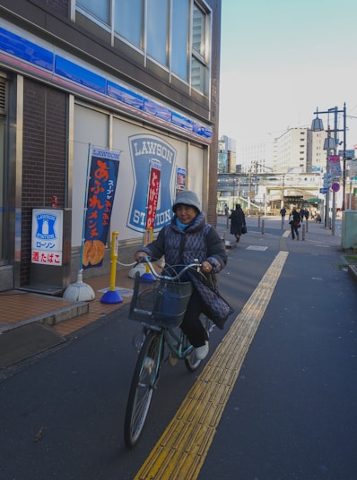 man in black jacket riding bicycle on sidewalk during daytime