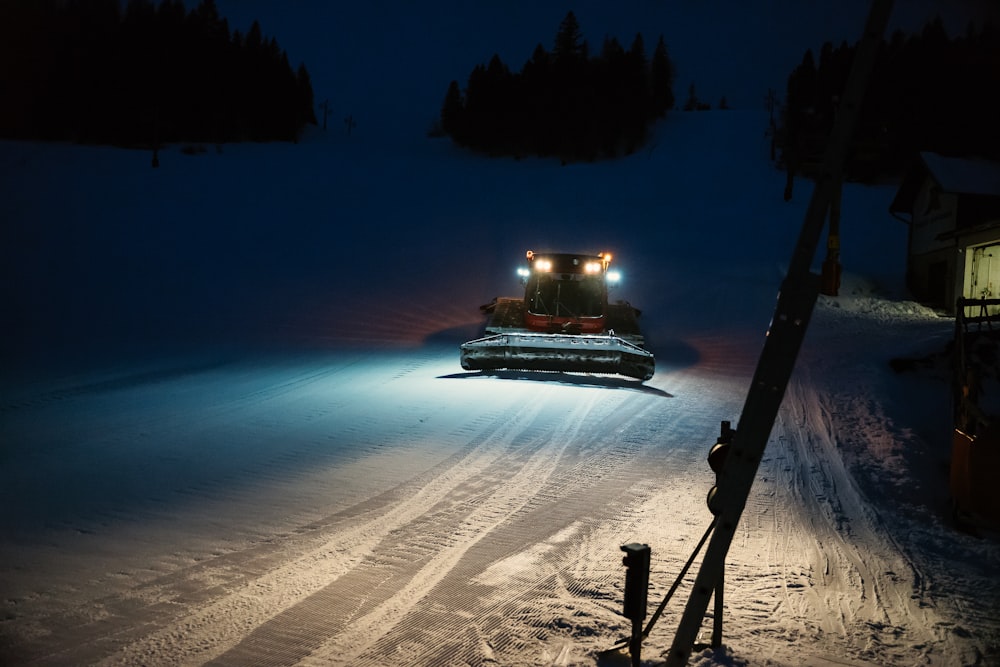 lighted house on snow covered ground during night time