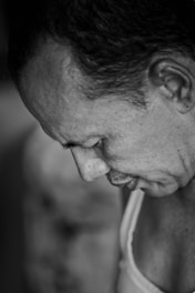 A close-up portrait in grayscale showing a thoughtful expression with subtle shadows.