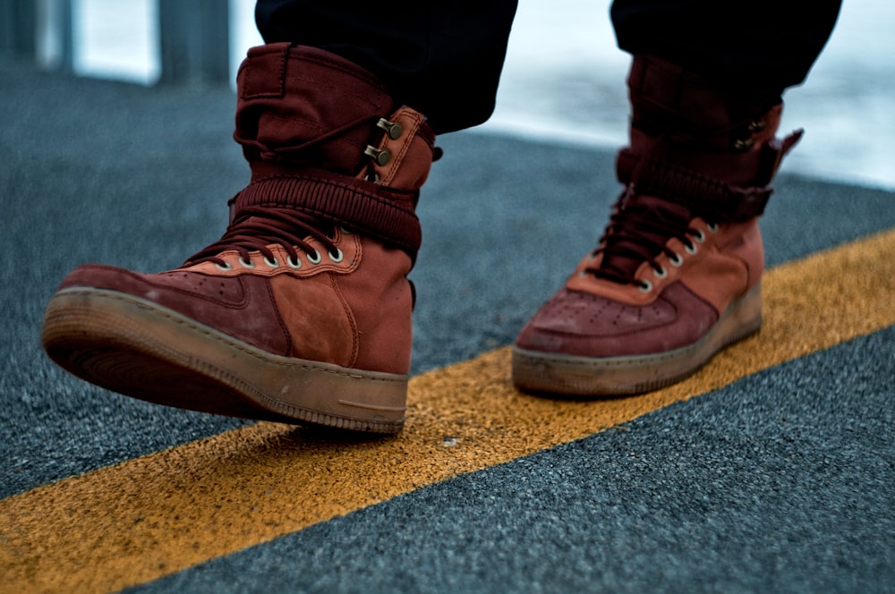 person wearing brown leather boots