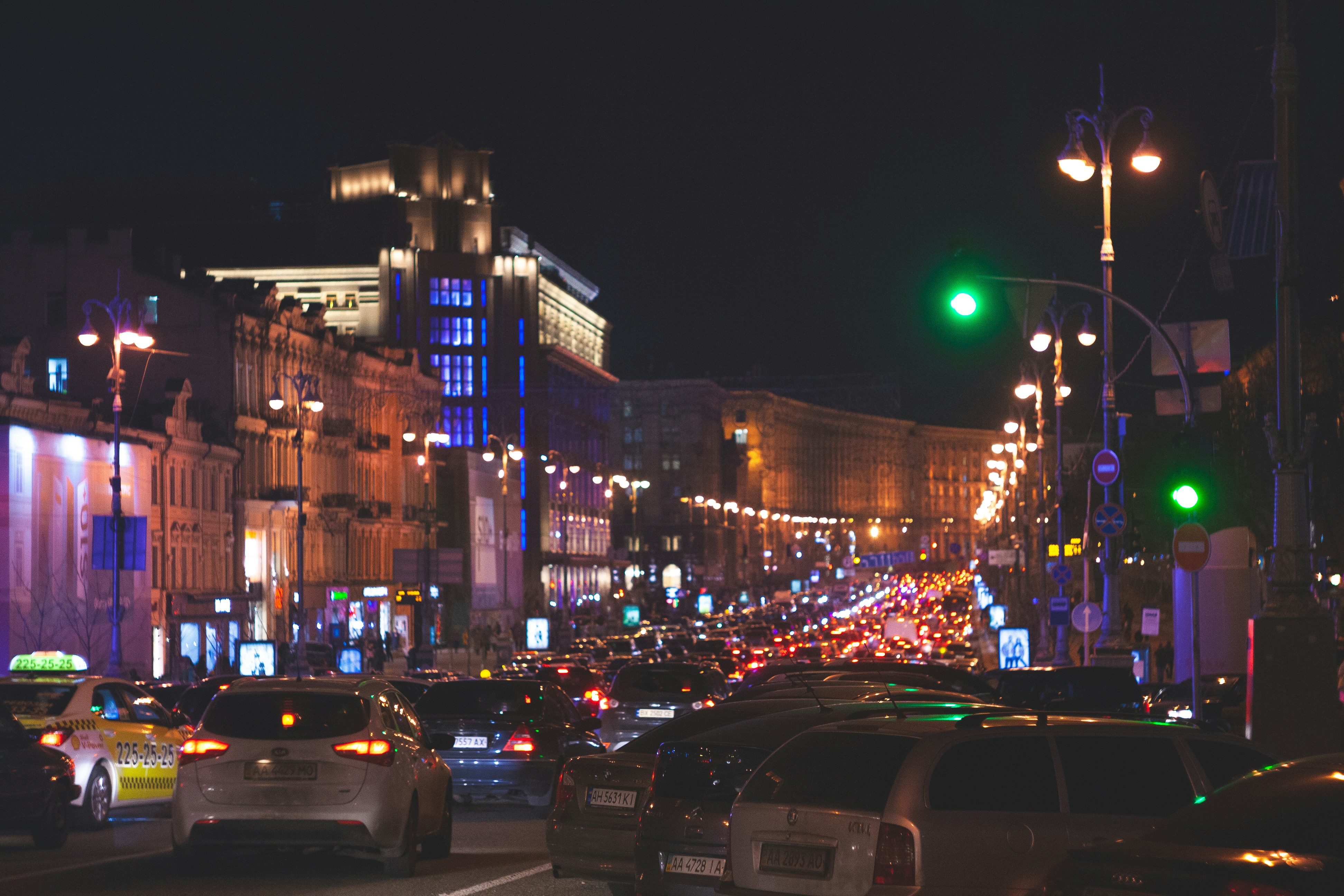 cars on road near high rise buildings during night time