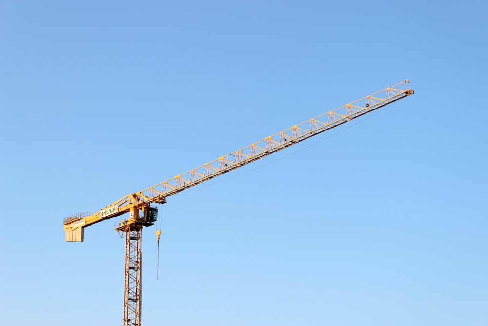 yellow crane under blue sky during daytime