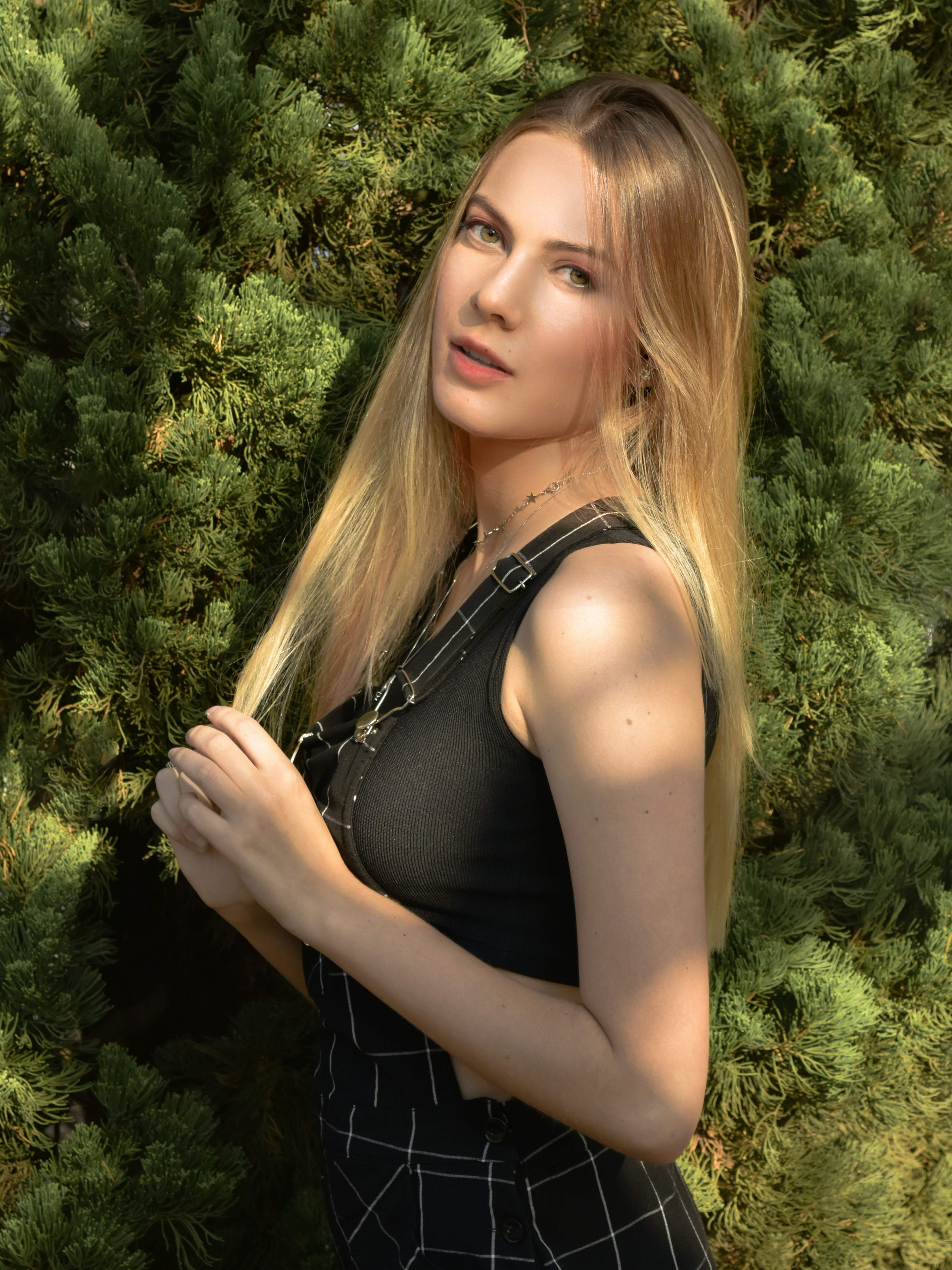 髪を掴む黒いタンクトップの女性