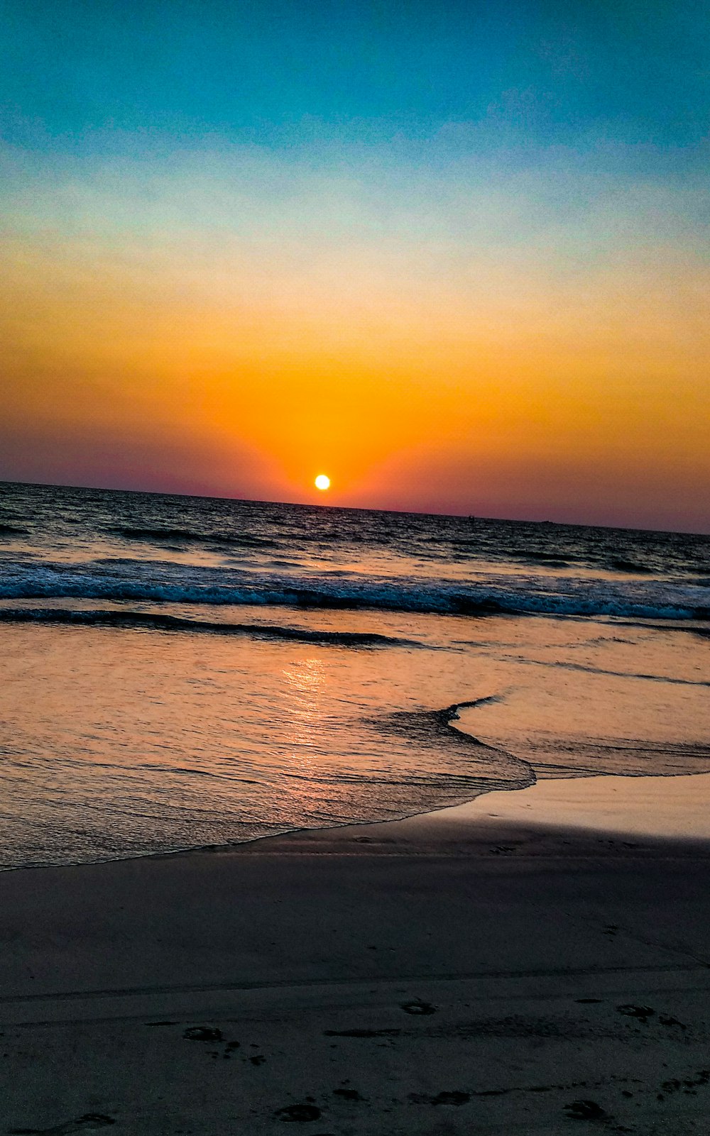 sea waves crashing on shore during sunset