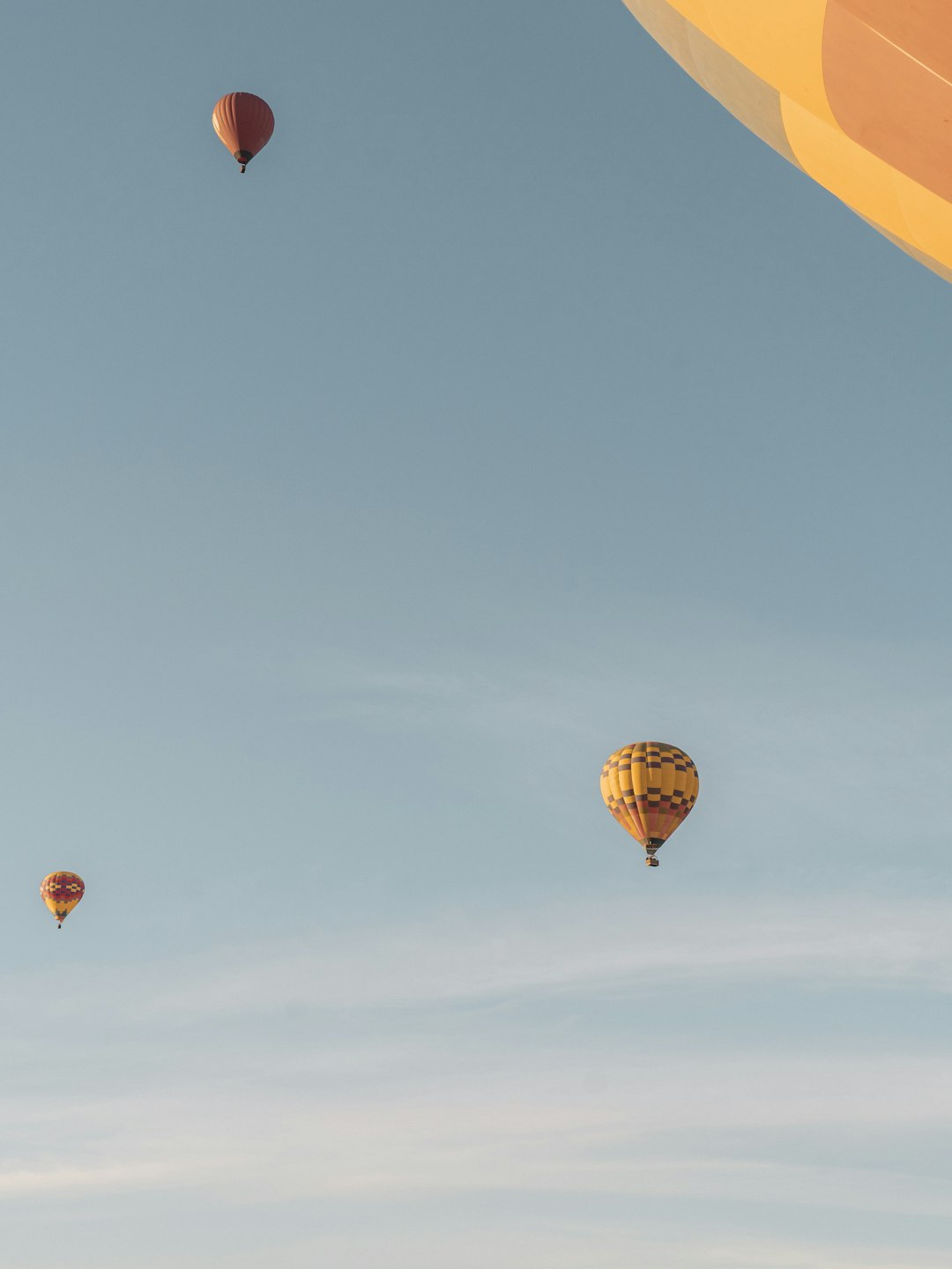 red and yellow hot air balloon in mid air under blue sky during daytime