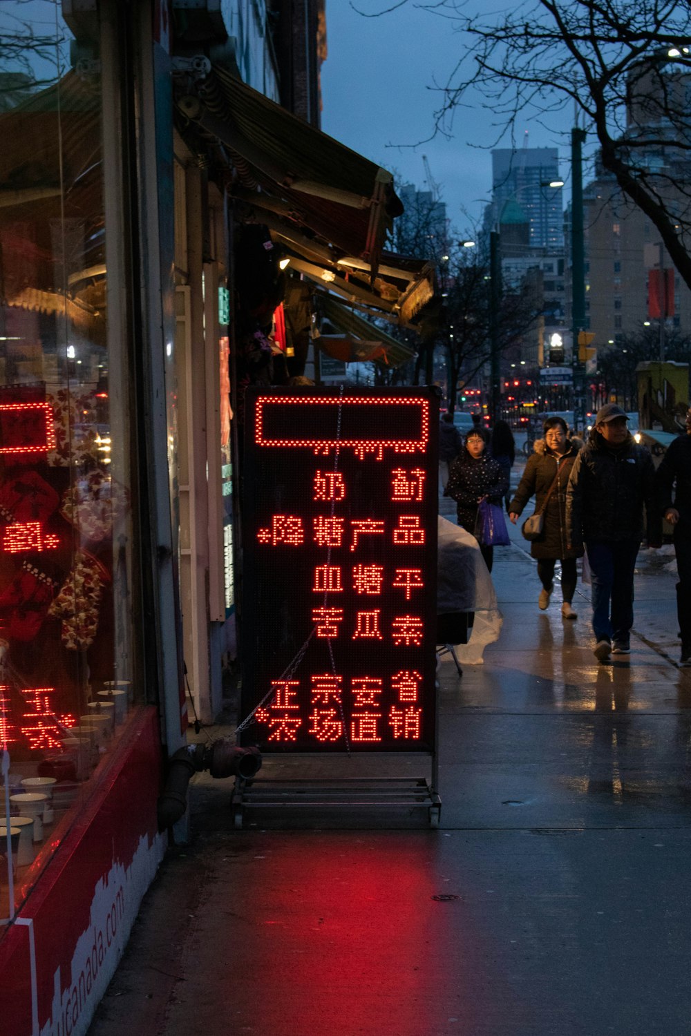 people walking on sidewalk during night time