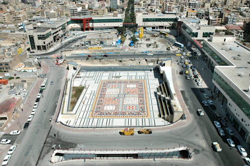 Aerial view of a large-scale commercial plaza with clear grid layout and muted color tones.