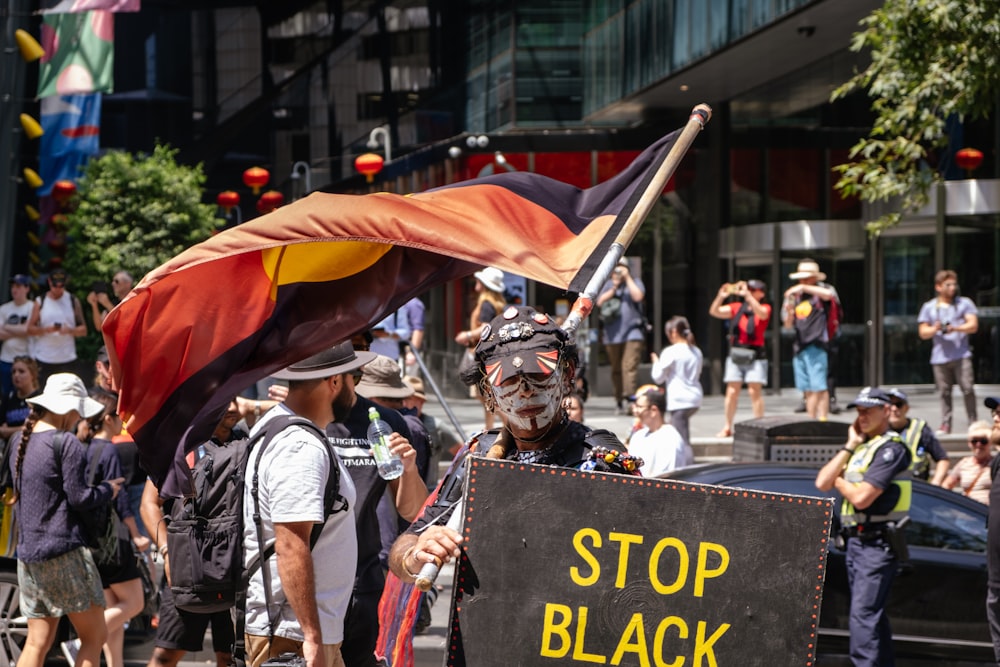 hombre con casco negro sosteniendo bandera roja y amarilla