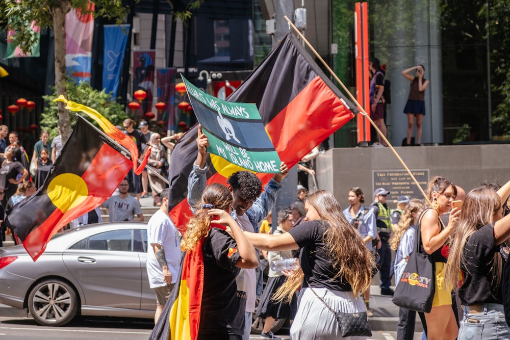 a group of people walking down a street holding flags