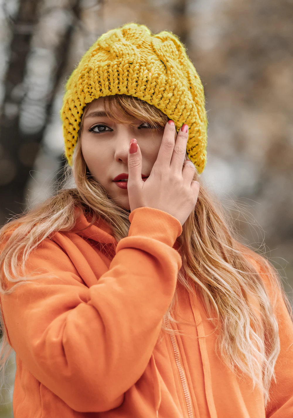 Yellow cable knit beanie with an orange hoodie