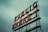 Red neon letters form the words 'PUBLIC MARKET' on a metal framework against an overcast sky.
