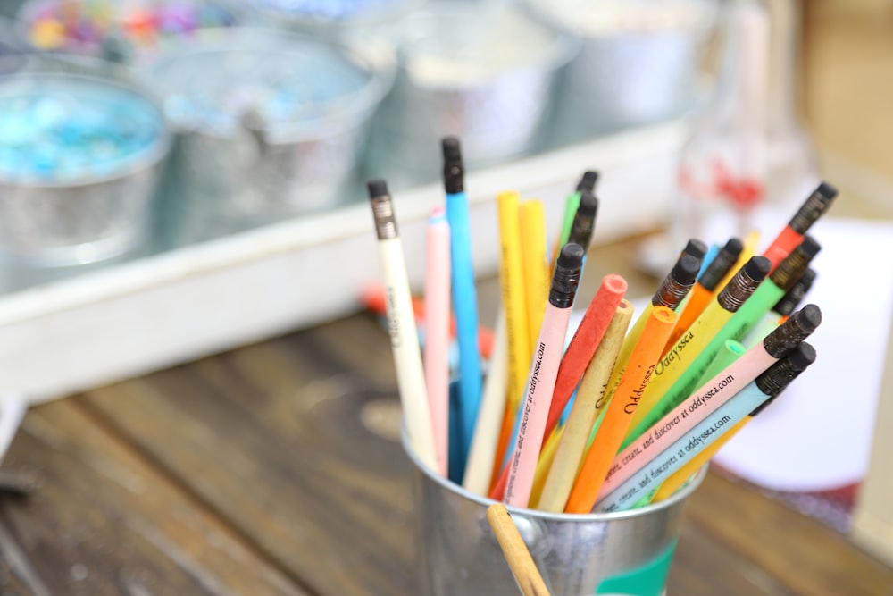 assorted color pencils in white plastic cup