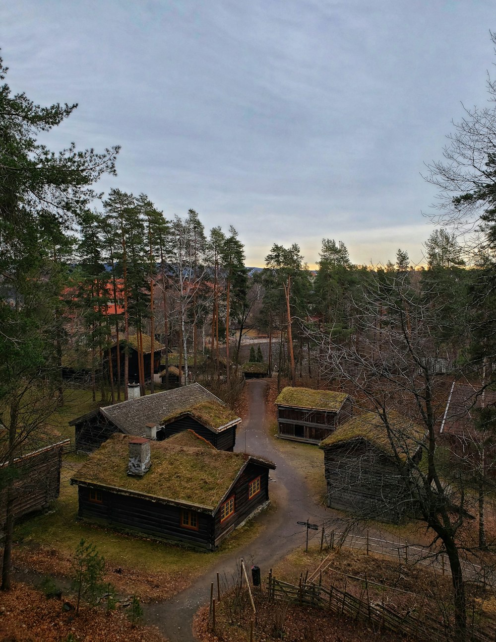 brown concrete house surrounded by trees under white clouds during daytime