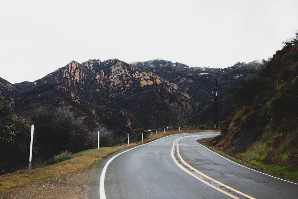 Carretera de hormigón gris cerca de la montaña durante el día