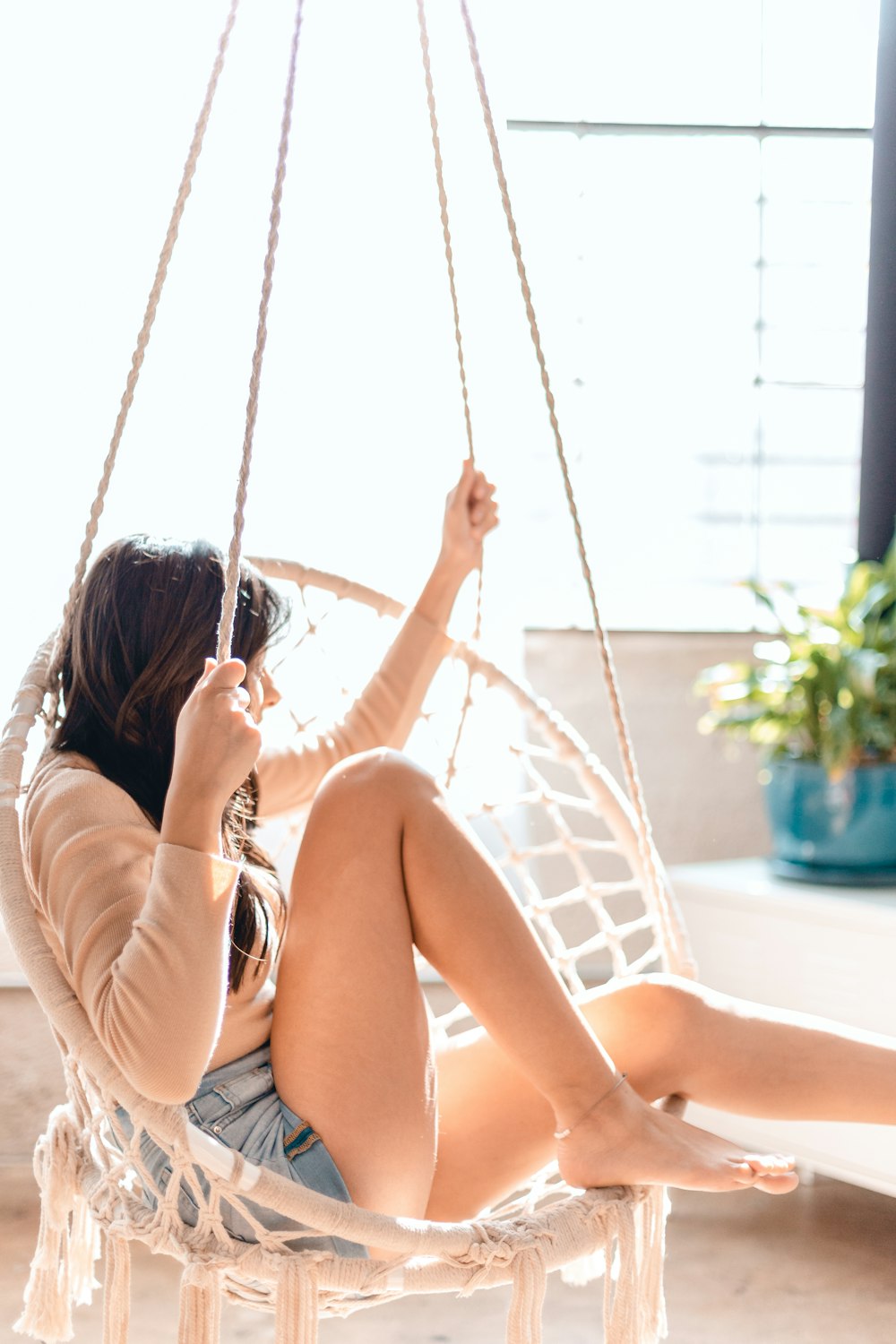 woman in white bikini sitting on white hammock