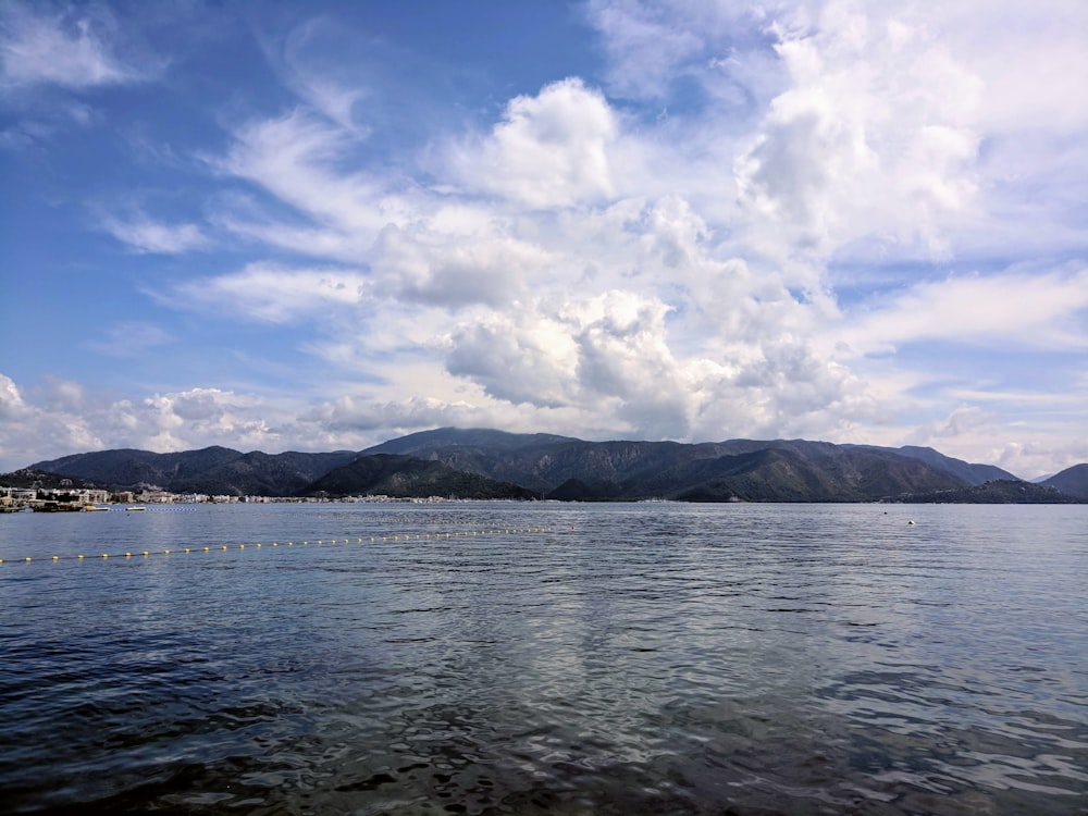 Cuerpo de agua bajo el cielo azul y nubes blancas durante el día