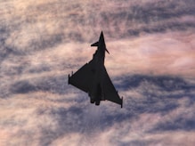 Background image with a blue and red gradient fading to white, featuring an F15 fighter jet.