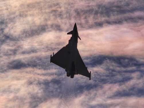 Background image with a blue and red gradient fading to white, featuring an F15 fighter jet.