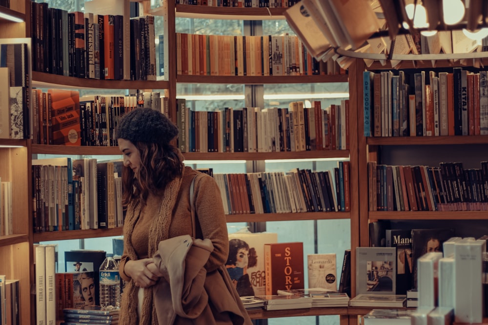 woman in brown coat reading book in library