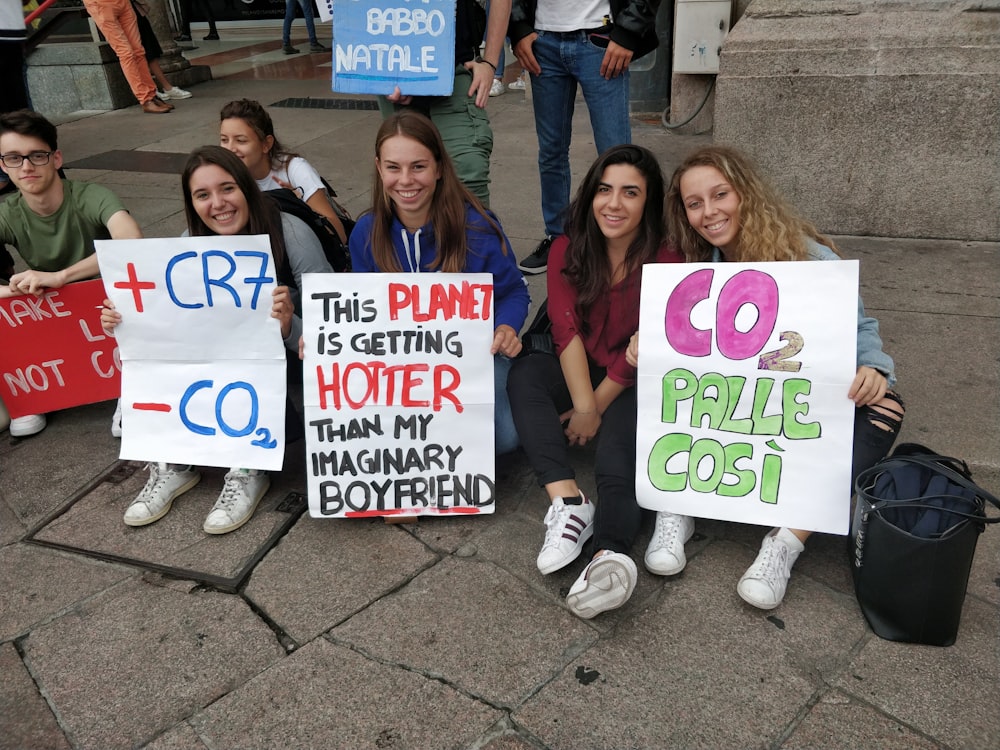 group of people holding white and blue happy birthday signage