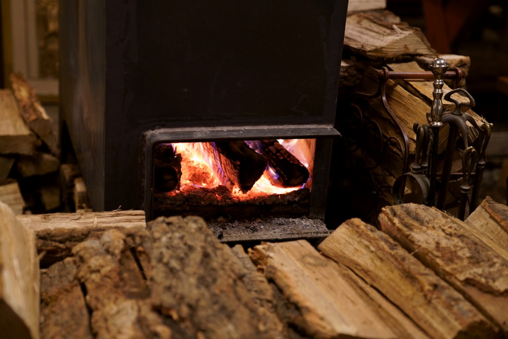 black wood burner near brown firewood