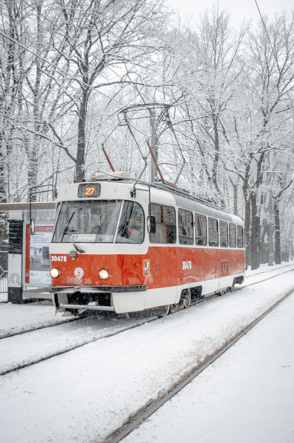 red and white tram on snow covered ground during daytime