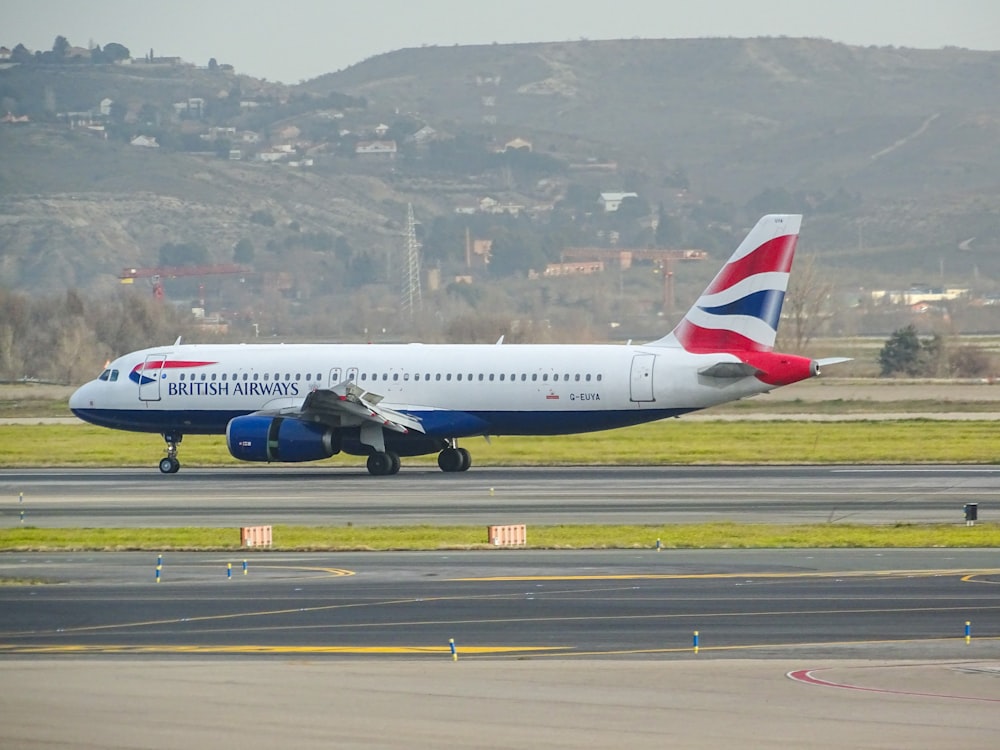 aereo bianco e rosso sull'aeroporto durante il giorno