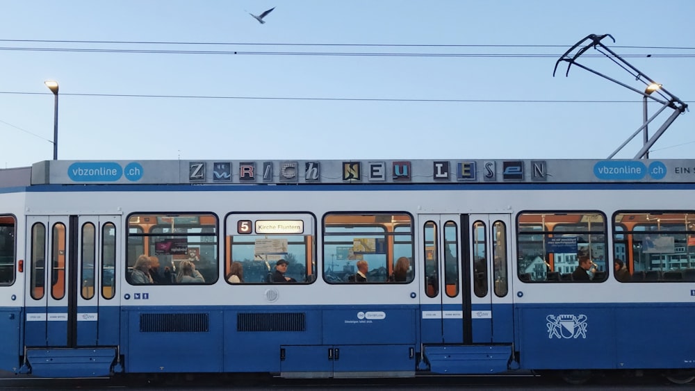 Tren blanco y azul en la estación de tren durante el día